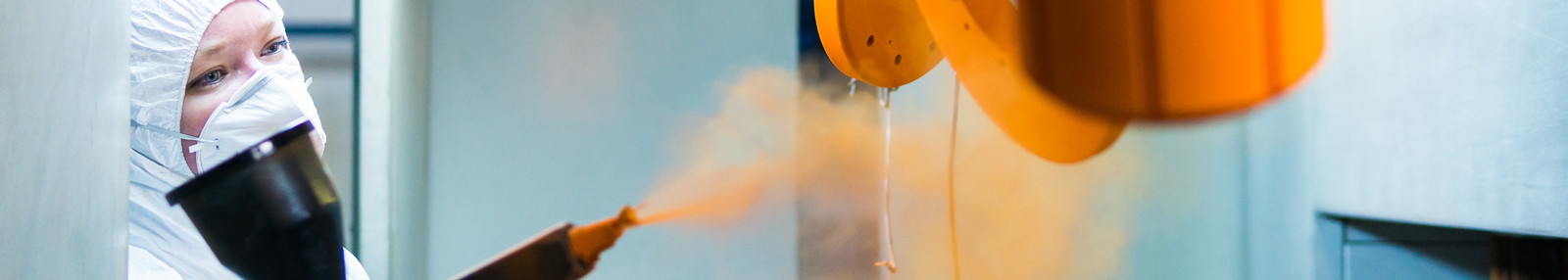 Woman sprays powder coating on elemetns